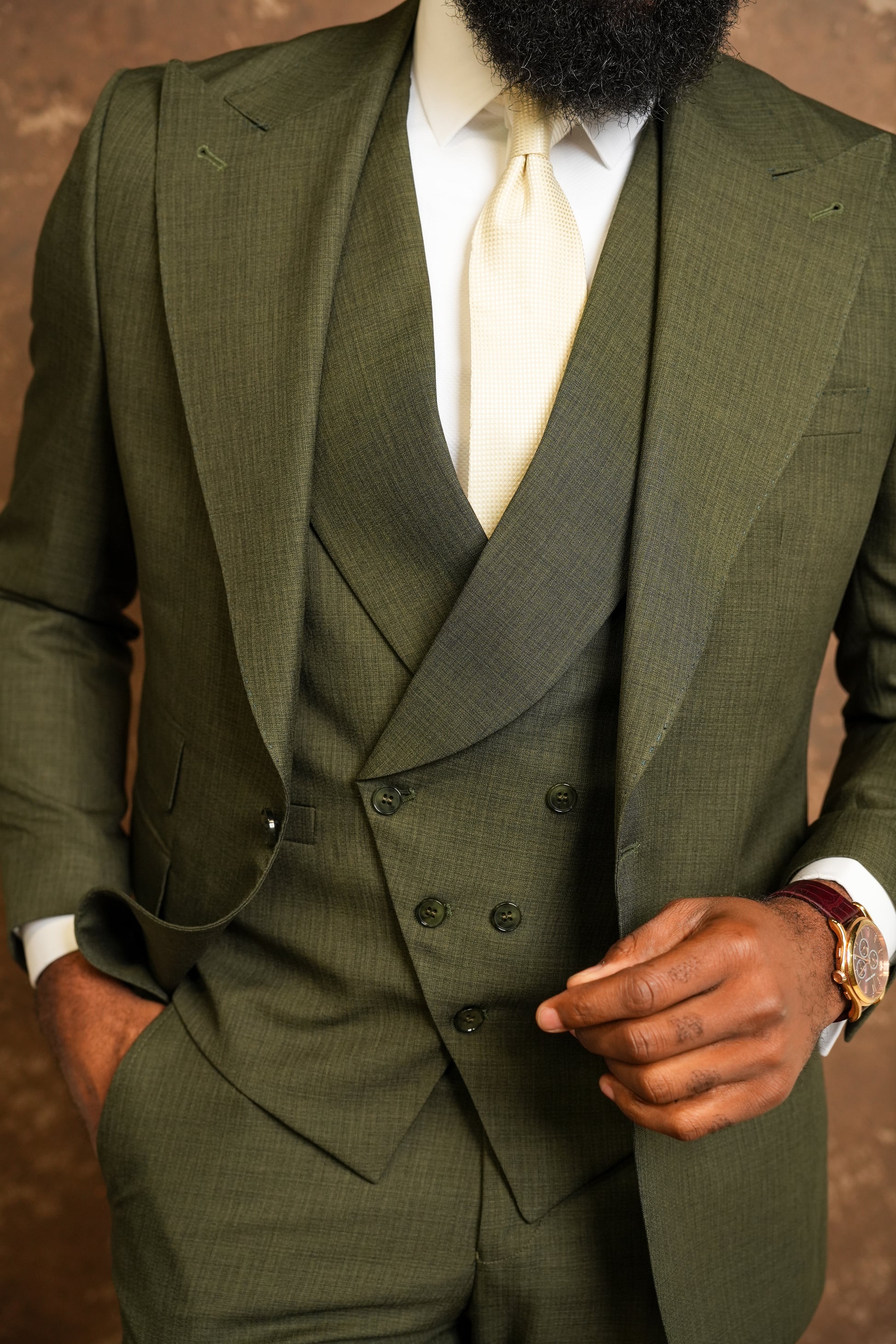 Green suit with white shirt and tie on a brown background