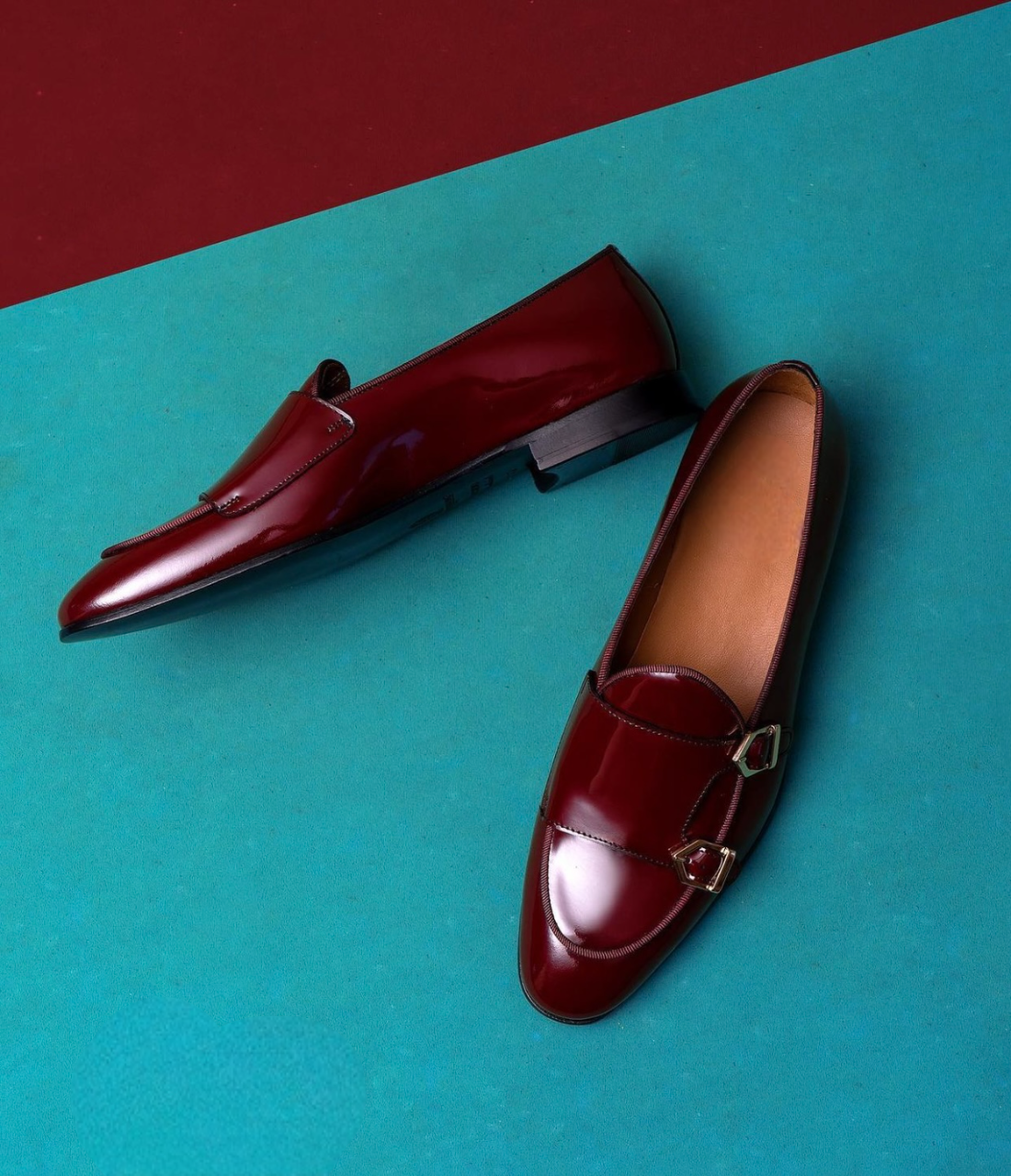 Pair of maroon loafers on a blue and red background