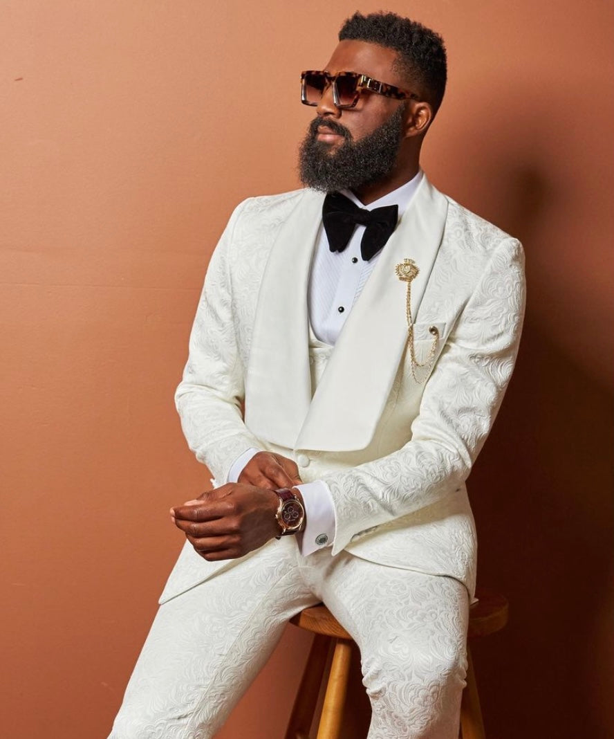man wearing a luxurious ivory paisley brocade tuxedo paired with a black bowtie