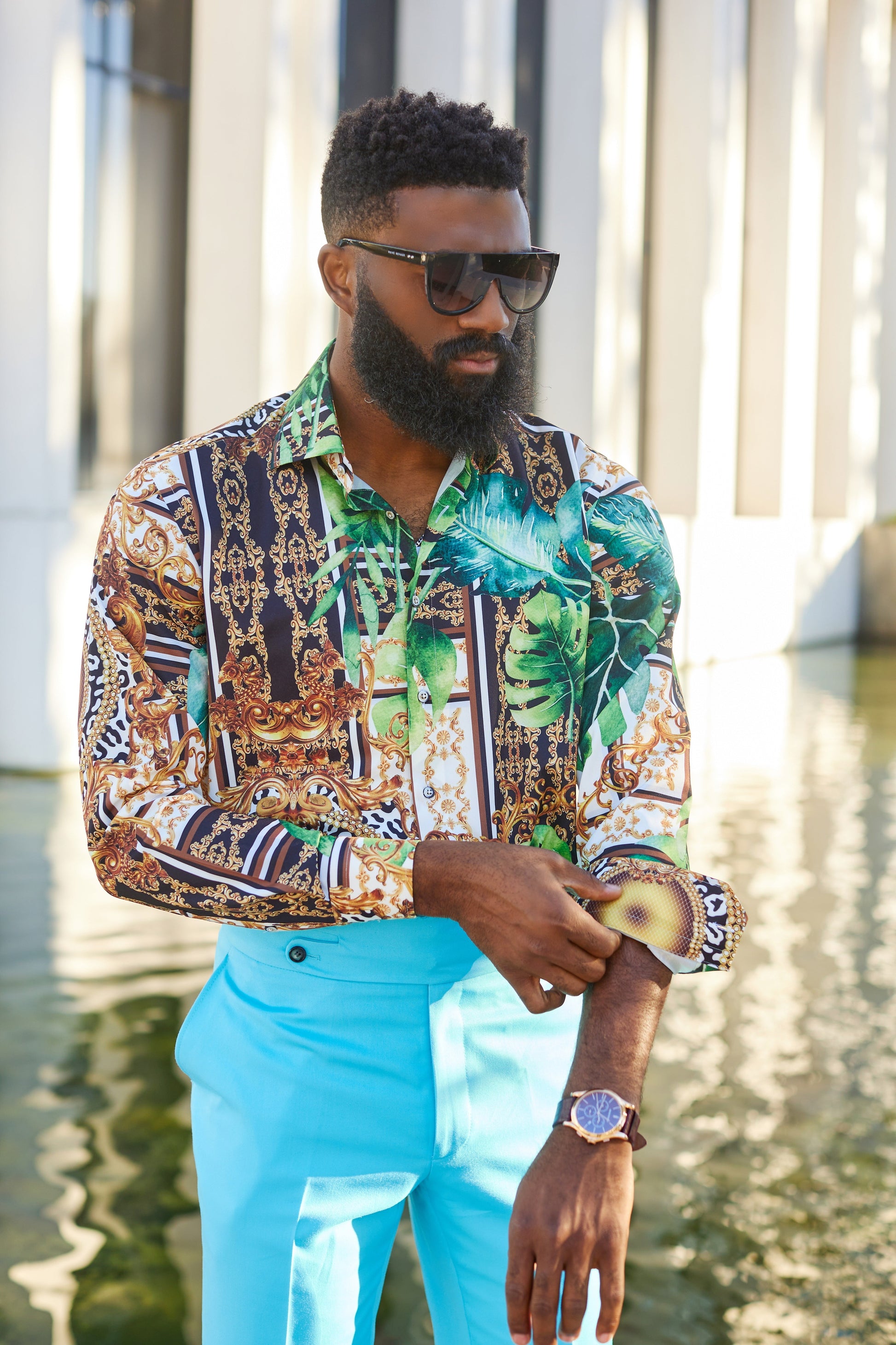 man wearing a green tulum floral shirt shirt with a bold, colorful Baroque-inspired pattern in green, gold, and white