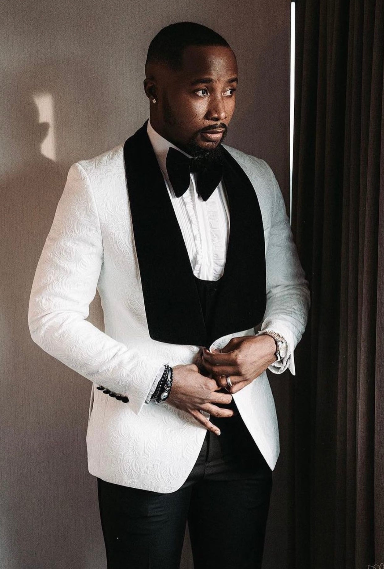 A man in Ivory Paisley With Black Velvet Shawl Looking Outside